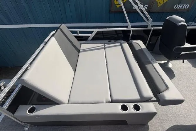 Slide: The Image of Sun Tracker Party Barge 22 RF DLX 2026 with gray seating and cup holders. - 29