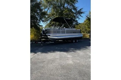 The Image of 2026 Sun Tracker Fishin' Barge 22 DLX pontoon boat parked outdoors. - 0