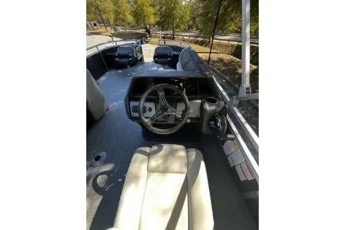 Slide: The Image of 2026 Sun Tracker Fishin' Barge 22 DLX interior with steering wheel and seating. - 5