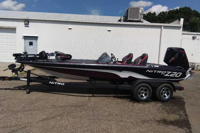 Slide: The Image of 2026 Nitro Z20 XL Pro bass boat on trailer, parked outside a white building. - 2