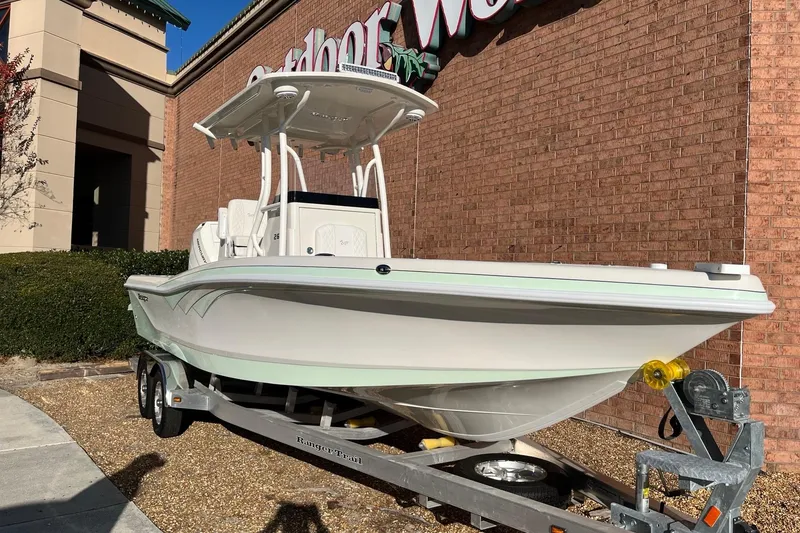 The Image of 2024 Ranger 2600 Bay boat on trailer outside a store, ready for adventure. - 0