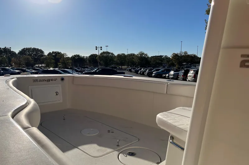 Slide: The Image of 2024 Ranger 2600 Bay boat interior with seating, parked outdoors under clear sky. - 8