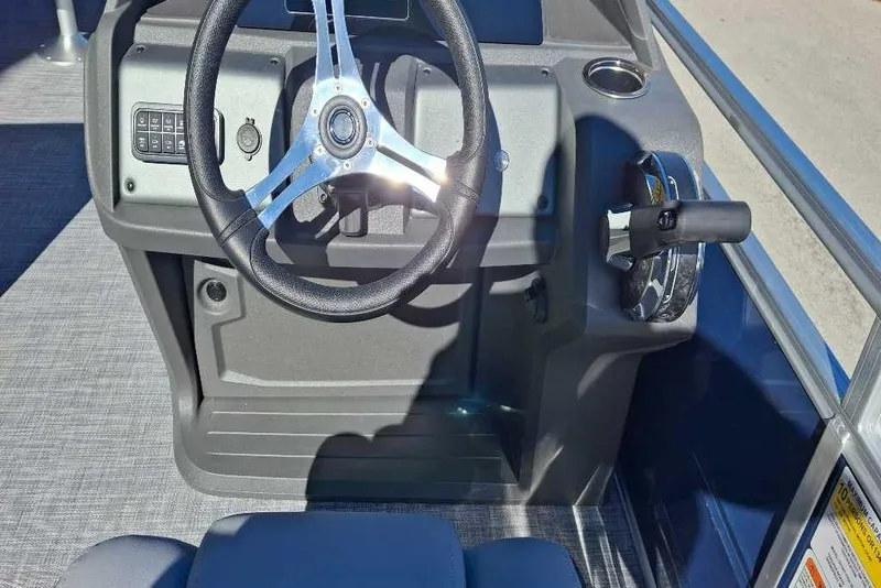 Slide: The Image of 2026 Sun Tracker SportFish 20 DLX boat steering console with controls and cup holder. - 76