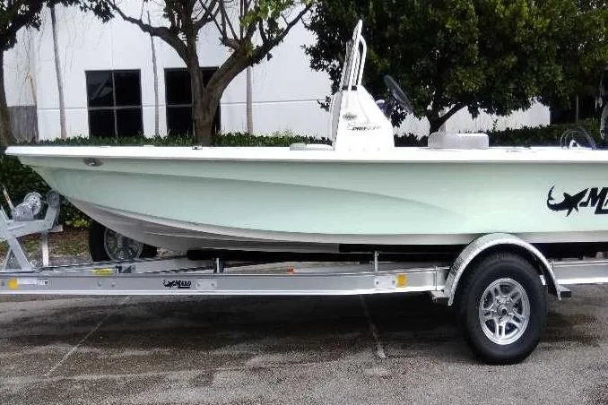Slide: The Image of 2026 Mako 18 Pro Skiff boat on trailer, parked outdoors. - 0