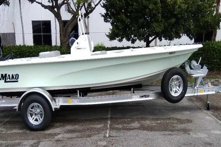 Slide: The Image of 2026 Mako 18 Pro Skiff boat on trailer, parked outdoors. - 1