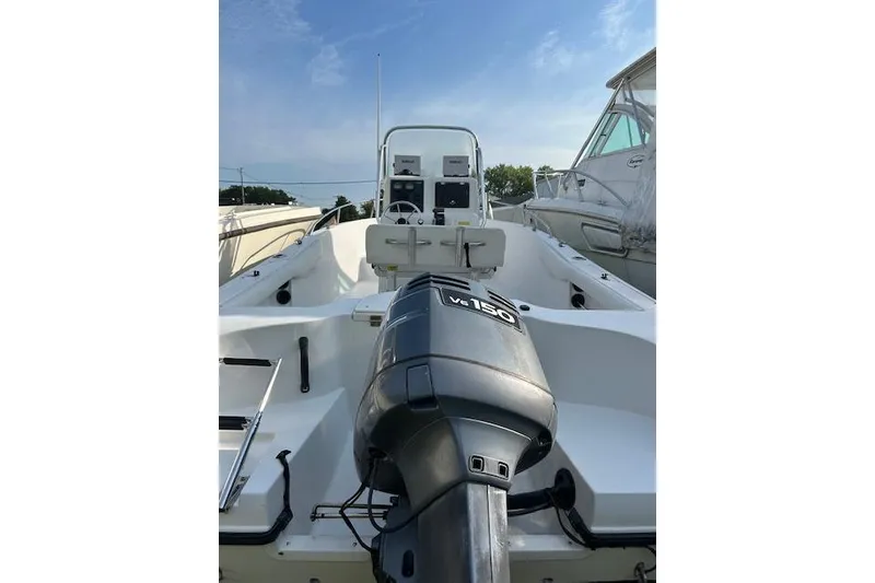 Slide: The Image of 2002 Seaswirl Striper 2101 Center Console boat with outboard motor, docked under clear sky. - 3