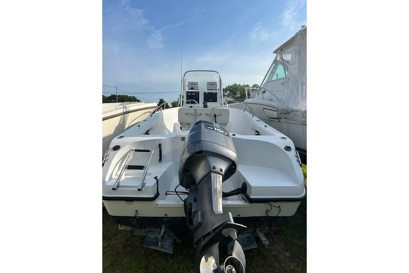 Slide: The Image of 2002 Seaswirl Striper 2101 Center Console boat with outboard motor, parked outdoors. - 4