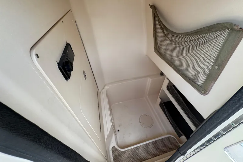 Slide: The Image of 2015 Grady-White Fisherman 257 interior storage compartment with netting and access panel. - 25