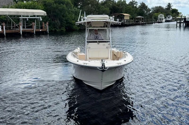 Slide: The Image of 2015 Grady-White Fisherman 257 boat navigating a calm river near docks and lush greenery. - 7