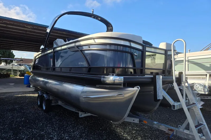 The Image of 2026 Godfrey Monaco 235 ULC pontoon boat on trailer, parked outdoors. - 0