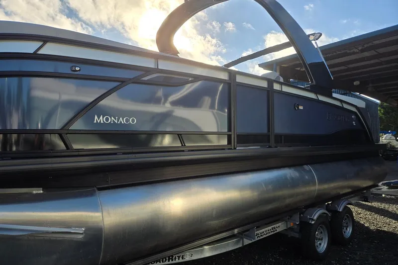 Slide: The Image of 2026 Godfrey Monaco 235 ULC pontoon boat on trailer under sunny sky. - 3