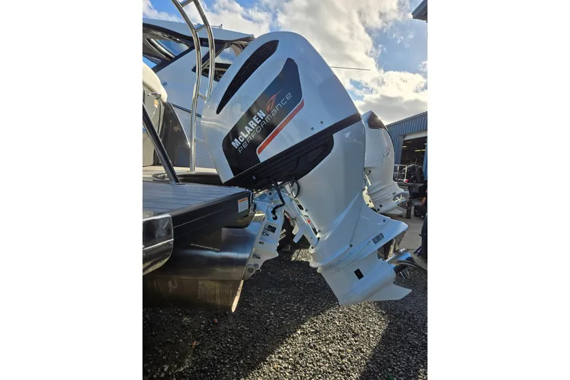 Slide: The Image of 2026 Godfrey Monaco 235 ULC boat with McLaren Performance outboard motor, parked outdoors. - 44