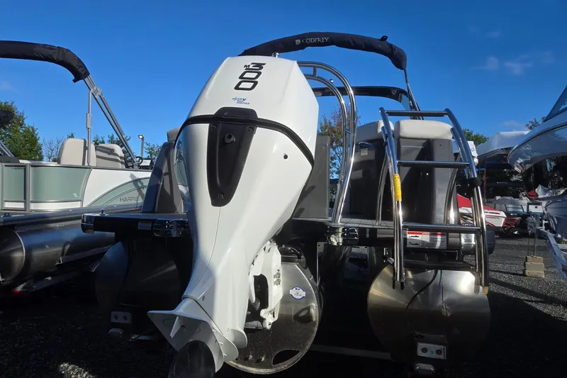 Slide: The Image of 2026 Godfrey Monaco 235 ULC pontoon boat with powerful outboard motor, docked outdoors. - 5