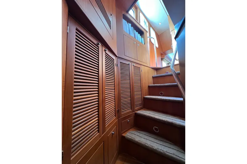 Slide: The Image of Interior staircase of 2002 Nordhavn 50 yacht with wooden cabinets and carpeted steps. - 10