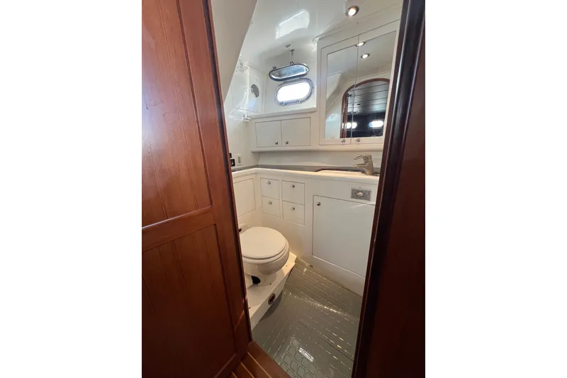 Slide: The Image of Bathroom interior of 2002 Nordhavn 50 yacht, featuring white cabinetry and porthole window. - 15