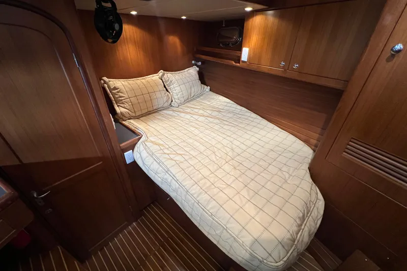 Slide: The Image of Cozy cabin interior of 2002 Nordhavn 50 yacht with wooden finish and comfortable bedding. - 17