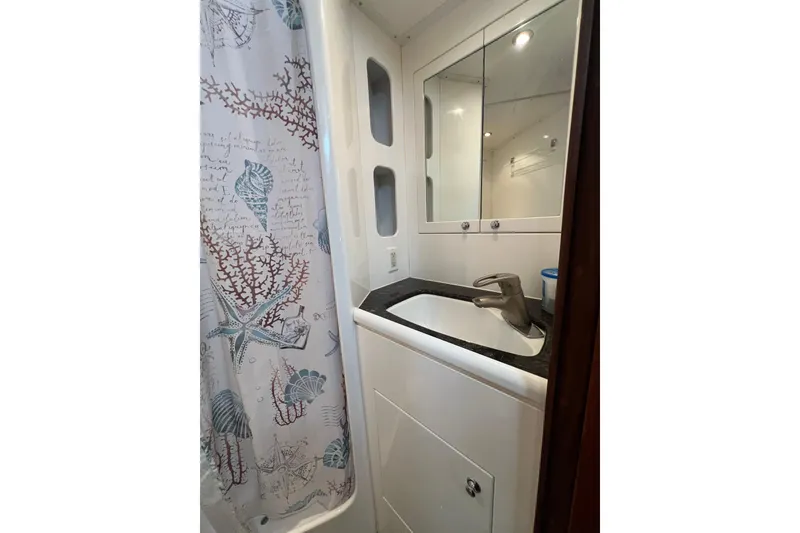 Slide: The Image of Bathroom in 2002 Nordhavn 50 yacht with nautical-themed shower curtain and modern sink. - 19