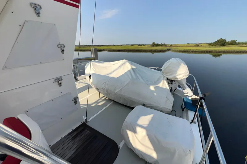 Slide: The Image of 2002 Nordhavn 50 yacht deck with covered equipment, calm water, and scenic landscape. - 25