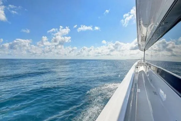 Slide: The Image of 2005 Hatteras 100 Motor Yacht cruising on open sea under clear blue sky. - 40