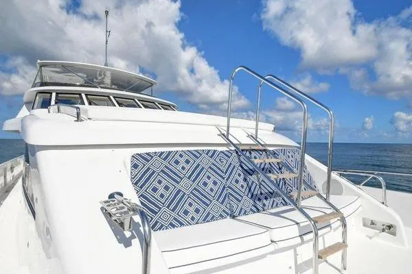 Slide: The Image of 2005 Hatteras 100 Motor Yacht deck with blue patterned seating under clear skies. - 41