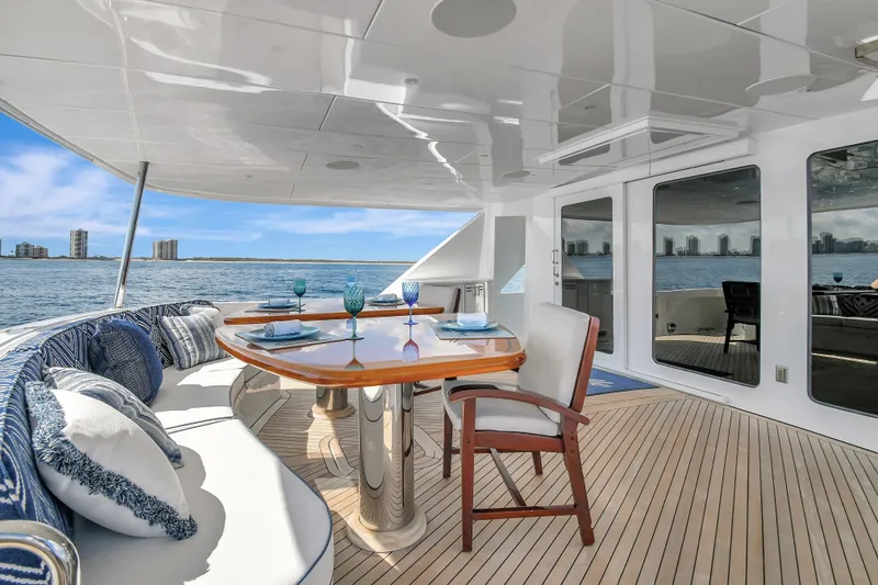 Slide: The Image of Luxurious 2005 Hatteras 100 Motor Yacht deck with elegant dining setup and ocean view. - 8