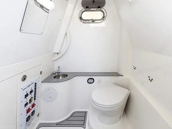 Slide: The Image of 2026 NauticStar 332 Offshore boat with dual Suzuki 300 outboard engines displayed indoors. - 10