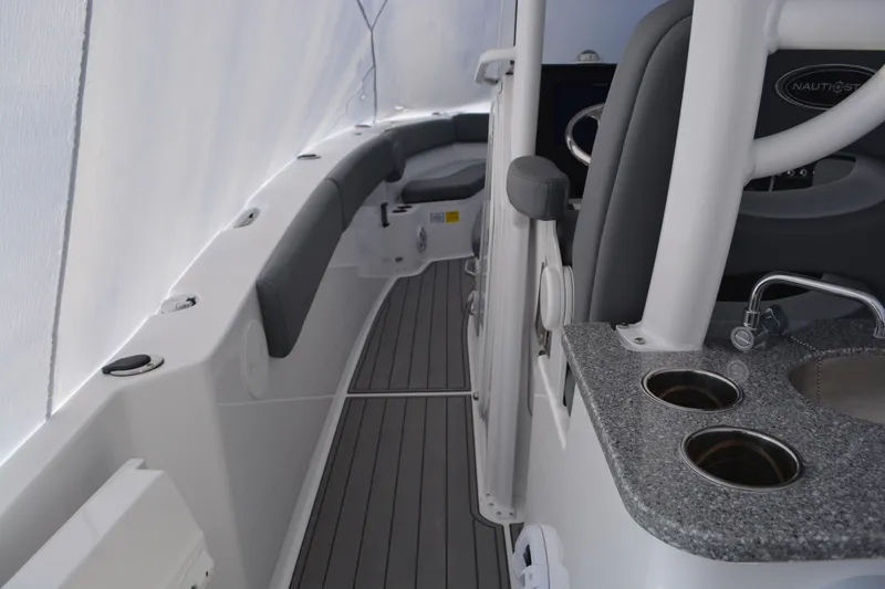 Slide: The Image of 2026 NauticStar 332 Offshore boat interior with sink, cup holders, and seating. - 25