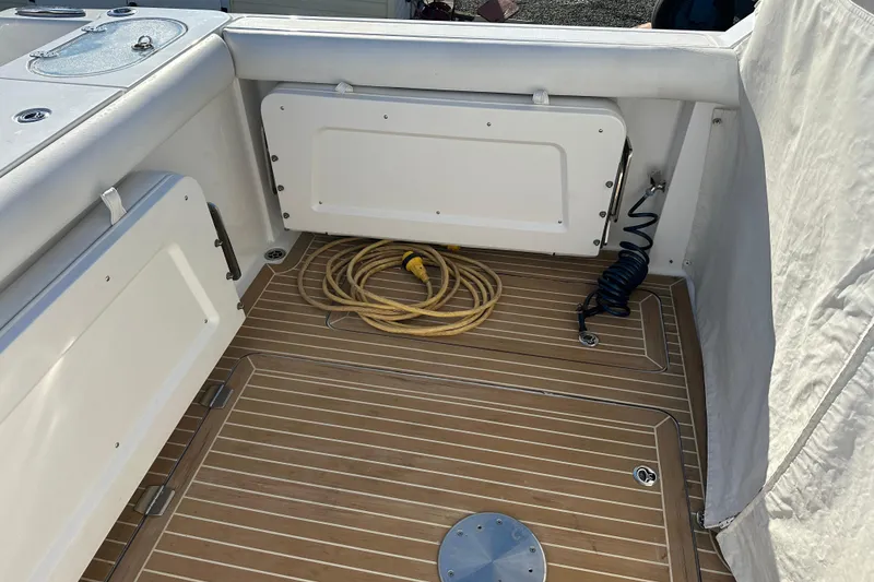 Slide: The Image of 2020 Southport 33DC boat deck with coiled hose and wooden flooring. - 11