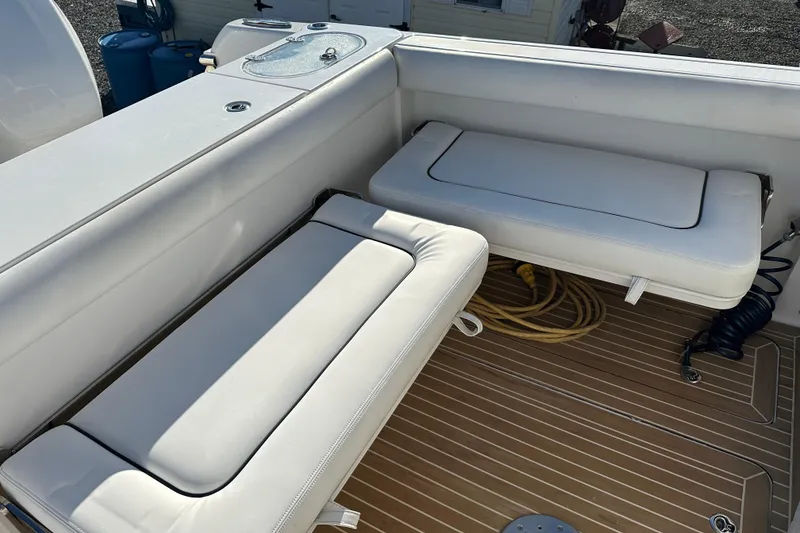 Slide: The Image of 2020 Southport 33DC boat interior with white cushioned seating and teak flooring. - 12