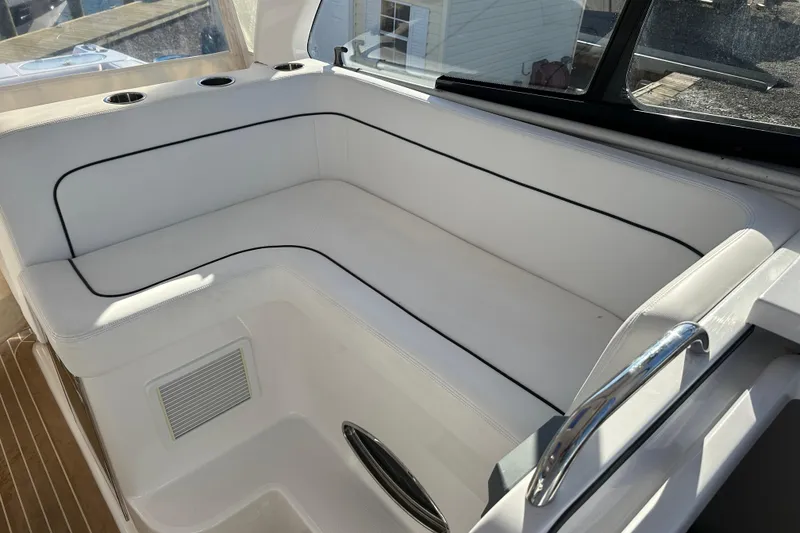 Slide: The Image of Luxurious white seating area on 2020 Southport 33DC boat, featuring cup holders and sleek design. - 13
