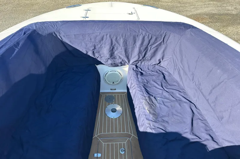 Slide: The Image of 2020 Southport 33DC boat interior with blue cover and wooden deck. - 16