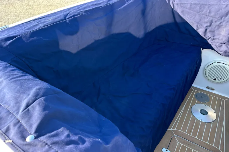 Slide: The Image of 2020 Southport 33DC boat interior with blue cover and wooden flooring. - 17