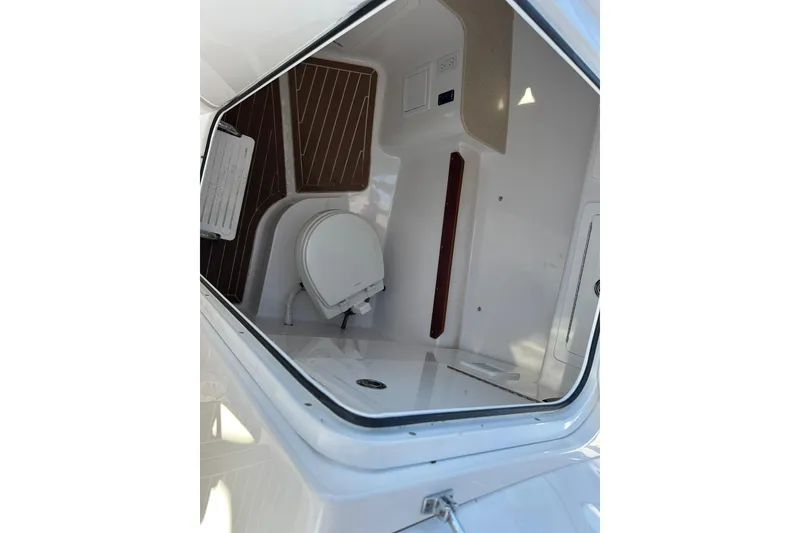Slide: The Image of 2020 Southport 33DC boat interior with compact toilet and wooden flooring. - 37
