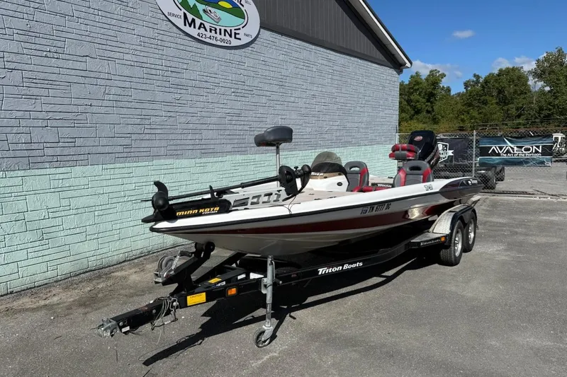 Slide: The Image of 2000 Triton TR21DC boat on trailer outside marine service building. - 2