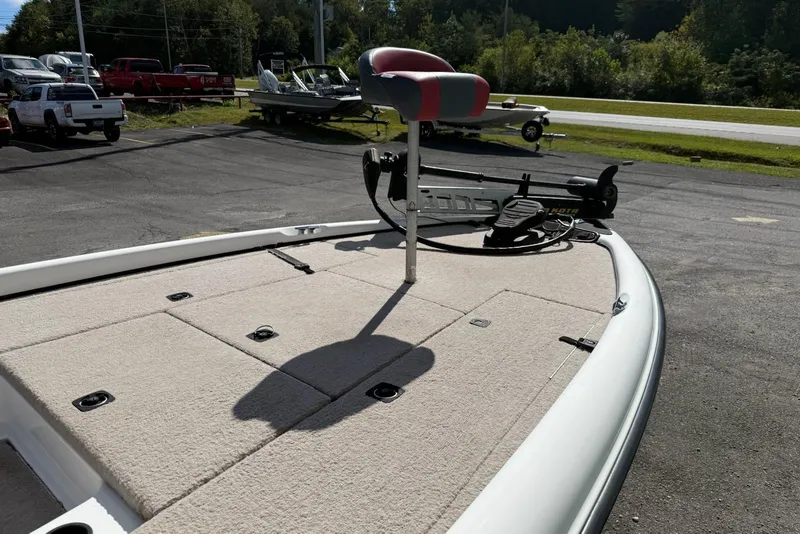 Slide: The Image of 2000 Triton TR21DC boat deck with seating and trolling motor in a parking lot. - 4