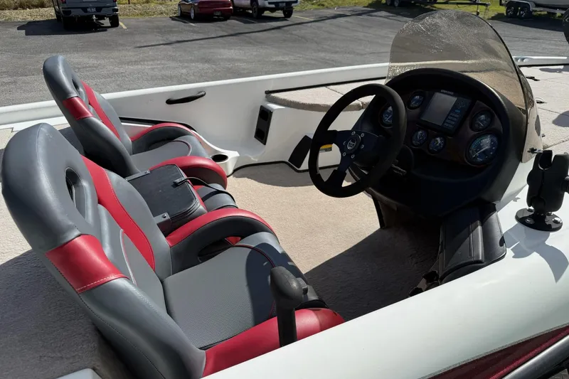 Slide: The Image of 2000 Triton TR21DC boat interior with red and gray seats, steering console, and dashboard. - 5