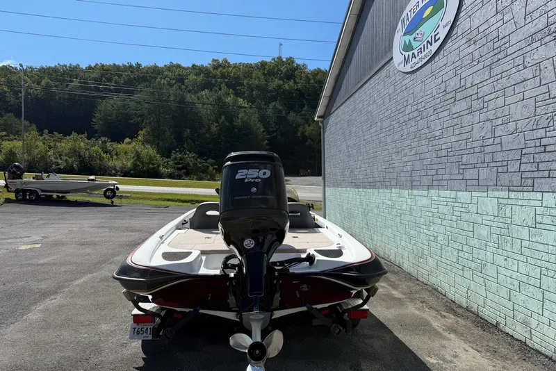 Slide: The Image of 2000 Triton TR21DC boat with 250 Pro motor parked outside a marine shop. - 7
