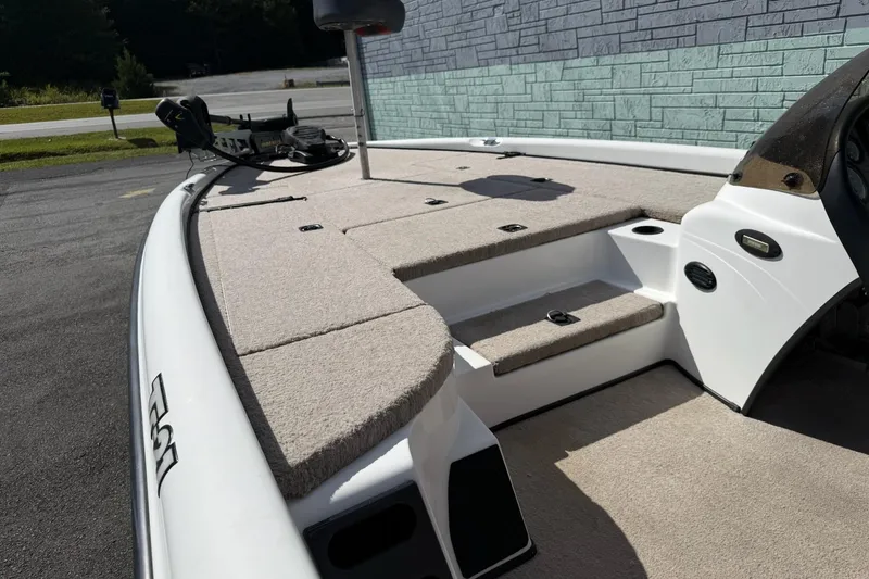 Slide: The Image of 2000 Triton TR21DC boat deck with carpeted surface and storage compartments. - 9
