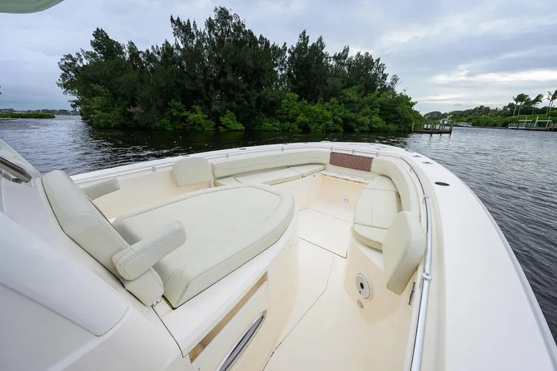 Slide: The Image of 2020 Cobia 350 CC boat interior with plush seating on a calm waterway. - 12
