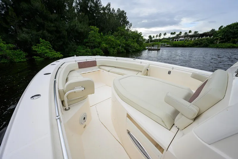 Slide: The Image of 2020 Cobia 350 CC boat interior with seating, surrounded by lush greenery and calm waters. - 19