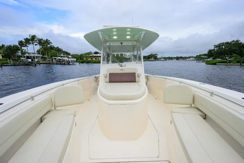 Slide: The Image of 2020 Cobia 350 CC boat on a serene waterway with lush greenery. - 20