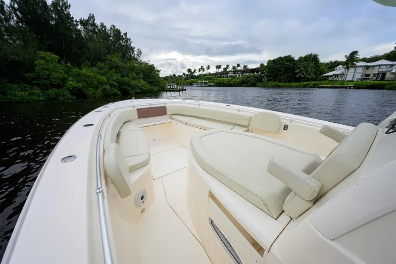 Slide: The Image of 2020 Cobia 350 CC boat interior with seating, on a calm river. - 23