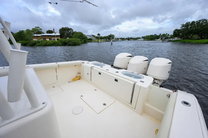 Slide: The Image of 2020 Cobia 350 CC boat with triple engines on a calm river. - 24