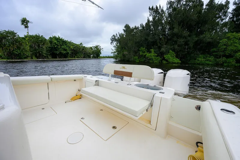 Slide: The Image of 2020 Cobia 350 CC boat interior with seating, near lush green shoreline. - 31
