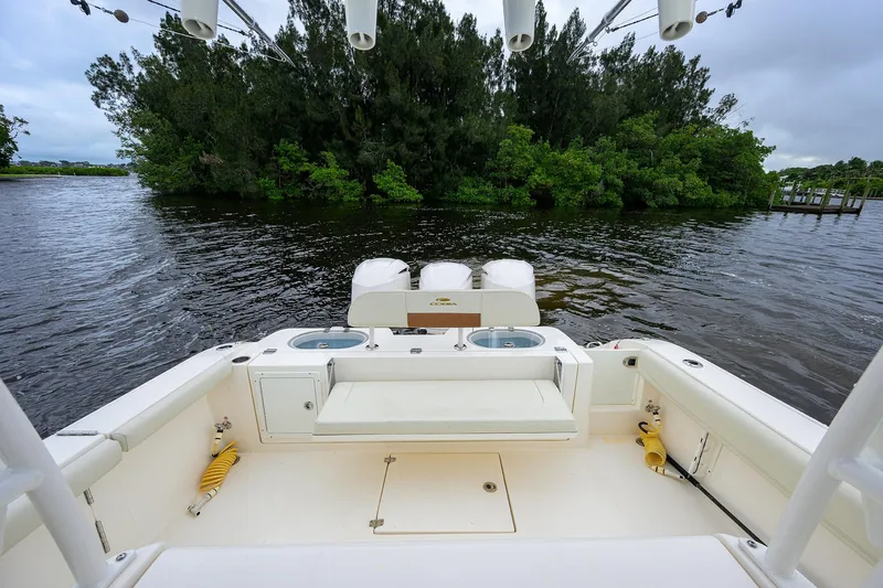 Slide: The Image of 2020 Cobia 350 CC boat interior with fishing amenities, docked near lush greenery. - 32