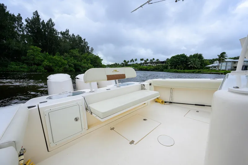Slide: The Image of 2020 Cobia 350 CC boat interior with seating, on a scenic river backdrop. - 33