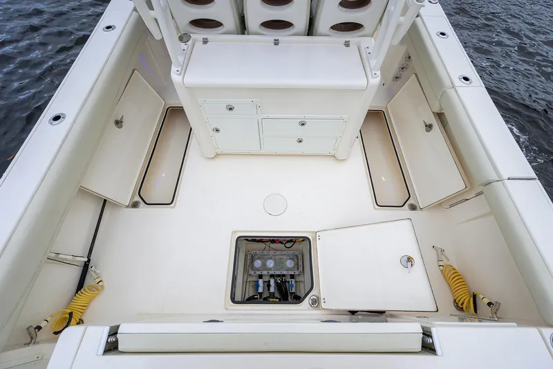 Slide: The Image of 2020 Cobia 350 CC boat deck with storage compartments and seating, on water. - 34