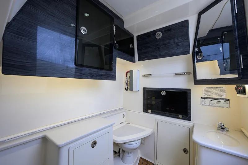 Slide: The Image of 2020 Cobia 350 CC boat interior bathroom with modern fixtures and storage cabinets. - 39