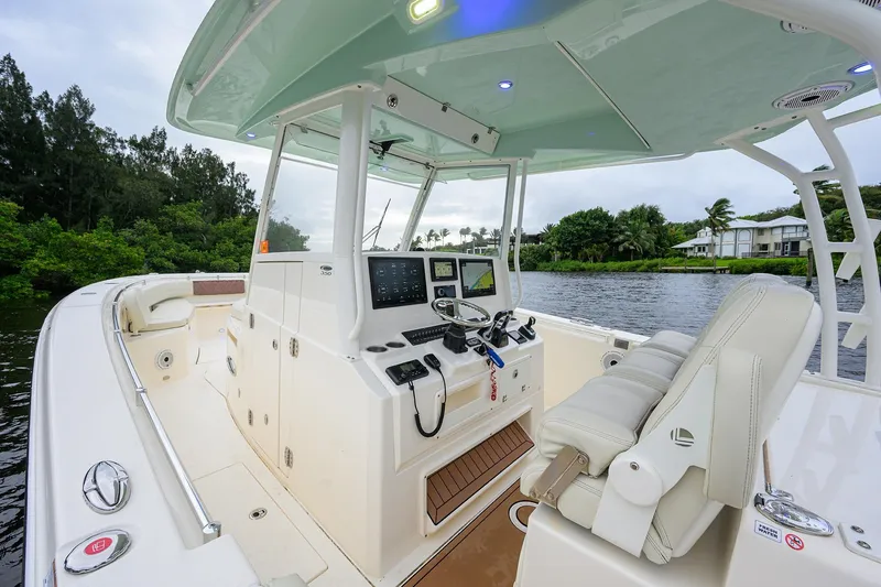 Slide: The Image of 2020 Cobia 350 CC boat interior with modern helm and seating on a scenic waterway. - 41