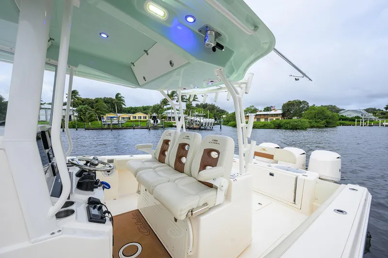 Slide: The Image of 2020 Cobia 350 CC boat interior with seating and steering, docked by waterfront homes. - 47